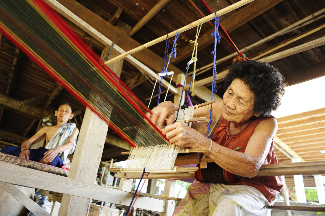 Thai textiles: Tai Phuan woman meticulously patterning Pha Sinh Teen Chok in Sukhothai